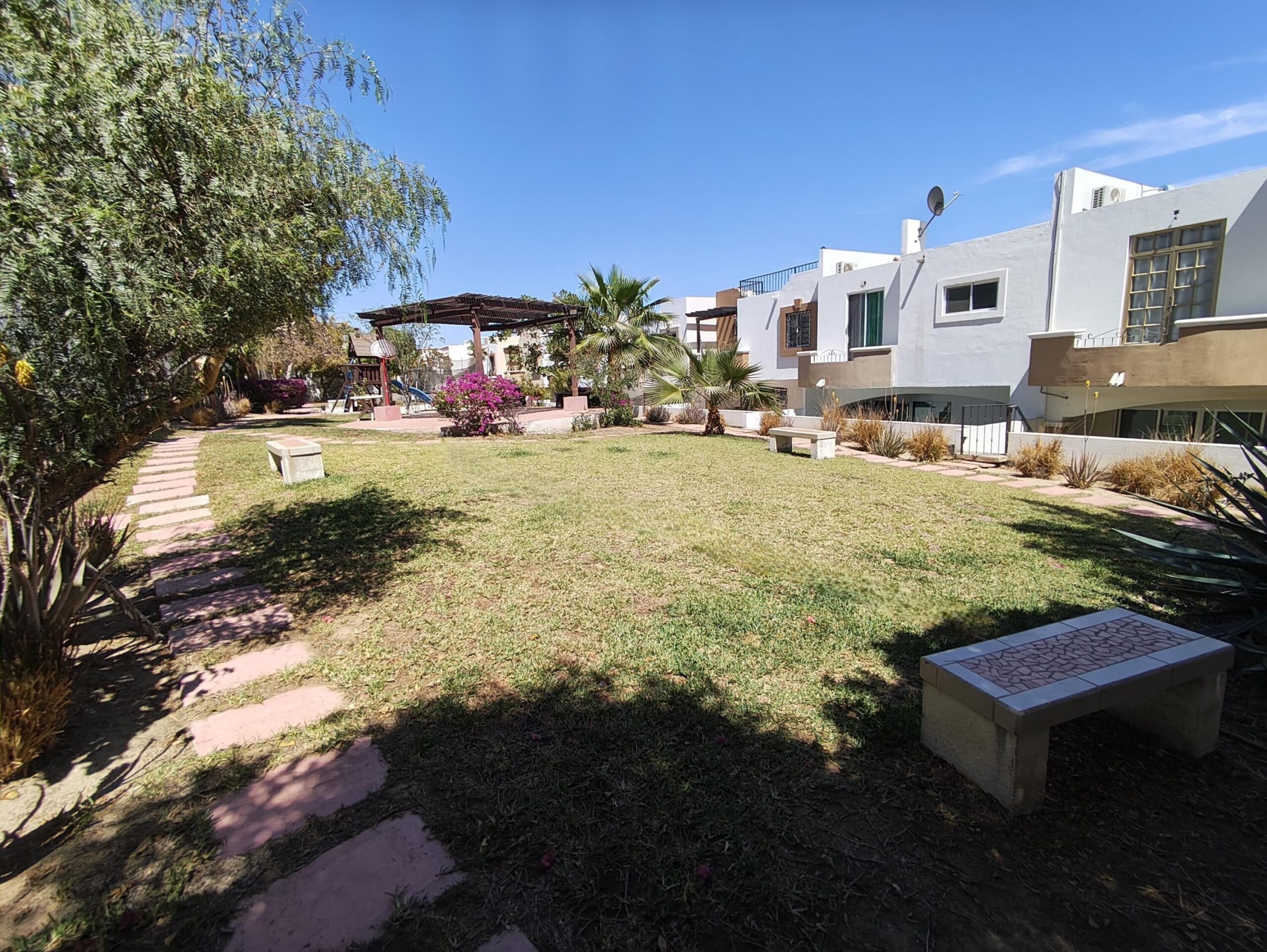 Cabo San Lucas Lomas Del Faro Casa en venta en Lomas del Faro Viejo, Los Cabos, con 225 m² de terreno y 130 m² de construcción distribuidos en dos niveles. La propiedad cuenta con amplia área de sala y comedor, cocina equipada con isla central y medio baño para visitas. En el exterior ofrece cochera para un vehículo, terraza, jardín y área de lavado de gran tamaño con pasto sintético.En planta baja se encuentran dos recámaras, cada una con clóset y baño completo privado, además de un espacio ideal para sala de televisión o área familiar. En la planta alta se ubica la recámara principal, que cuenta con clóset, baño completo, área de estudio y acceso a una terraza privada.La vivienda dispone de cisterna con capacidad de 10,000 litros y ofrece espacios amplios, funcionales y modernos. – Faro San José Del Cabo, Cabo San Lucas, BS